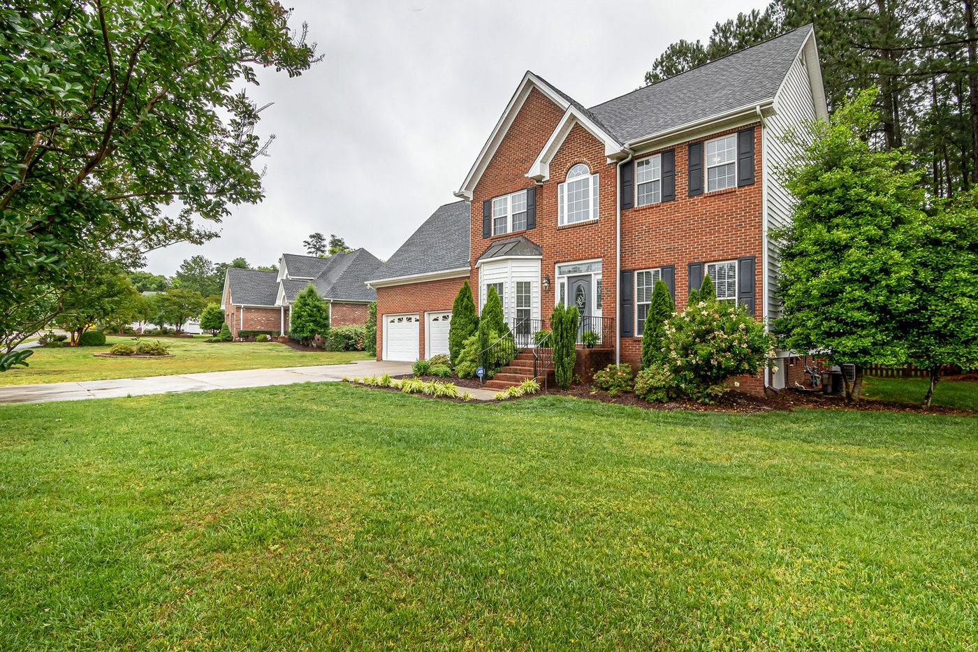 Two-story brick home with a broad healthy lawn