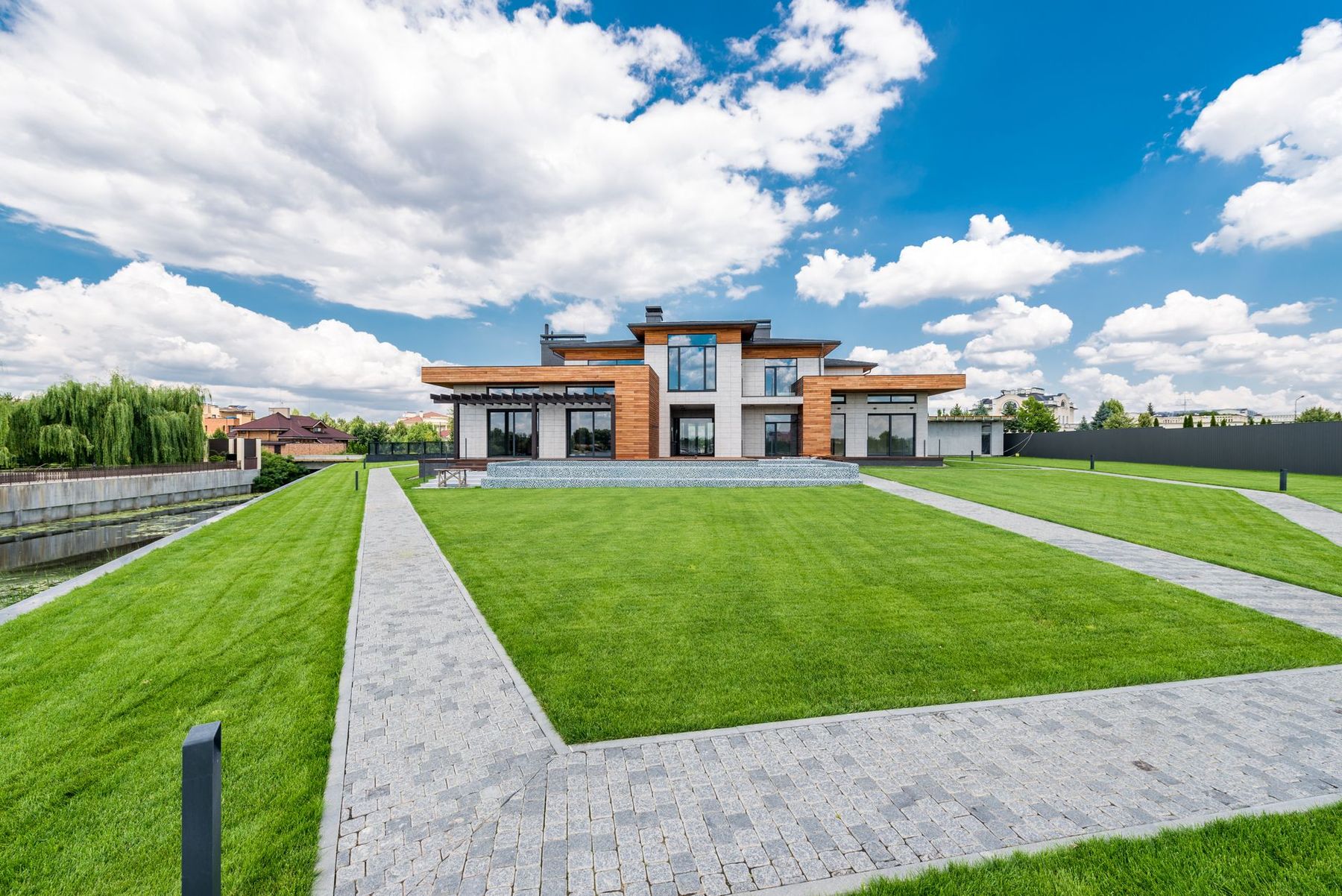 Landscaped front yard with paver walkways and a fresh cut lawn