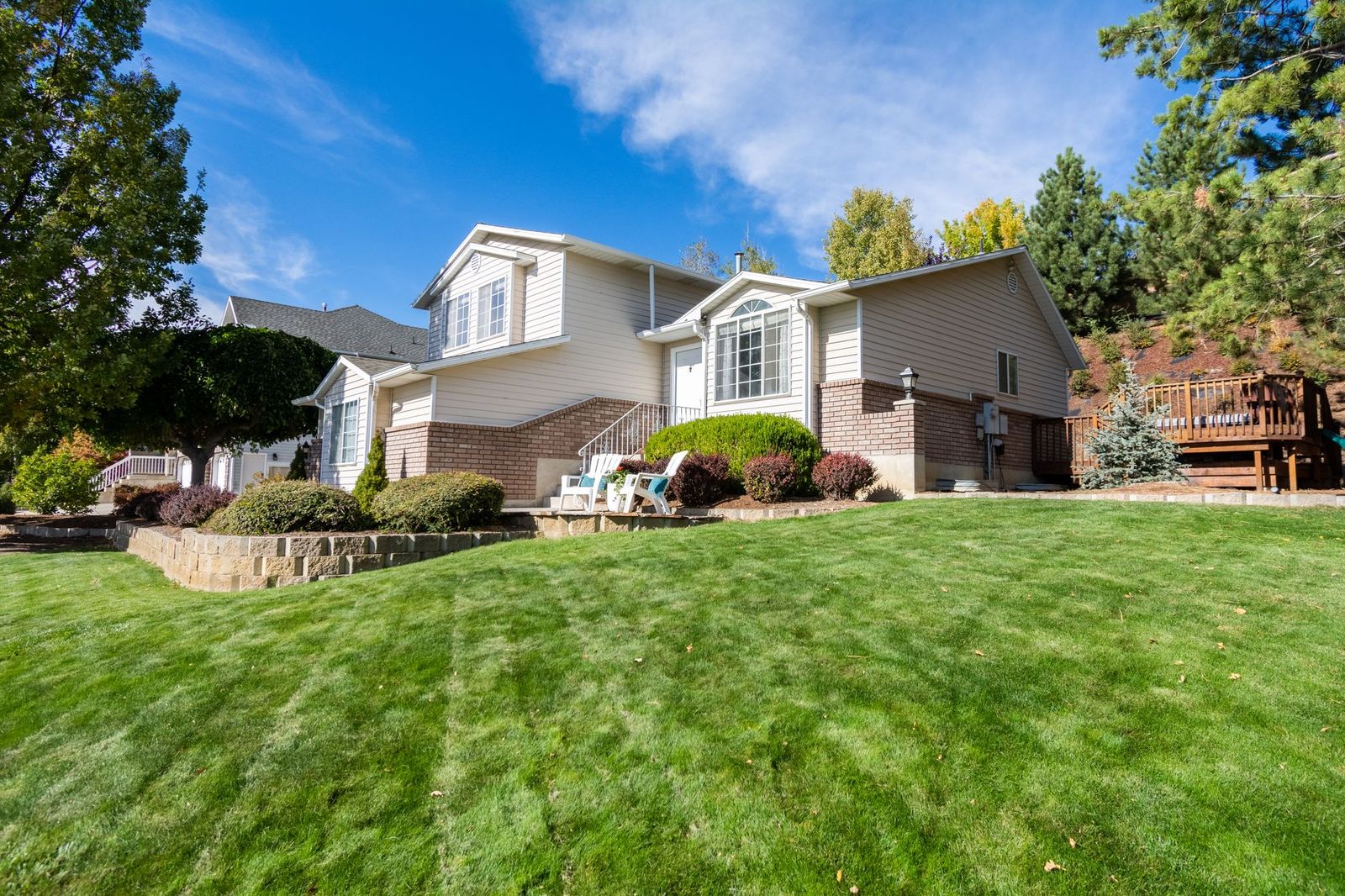 Home with a full green lawn and tidy foundation planting