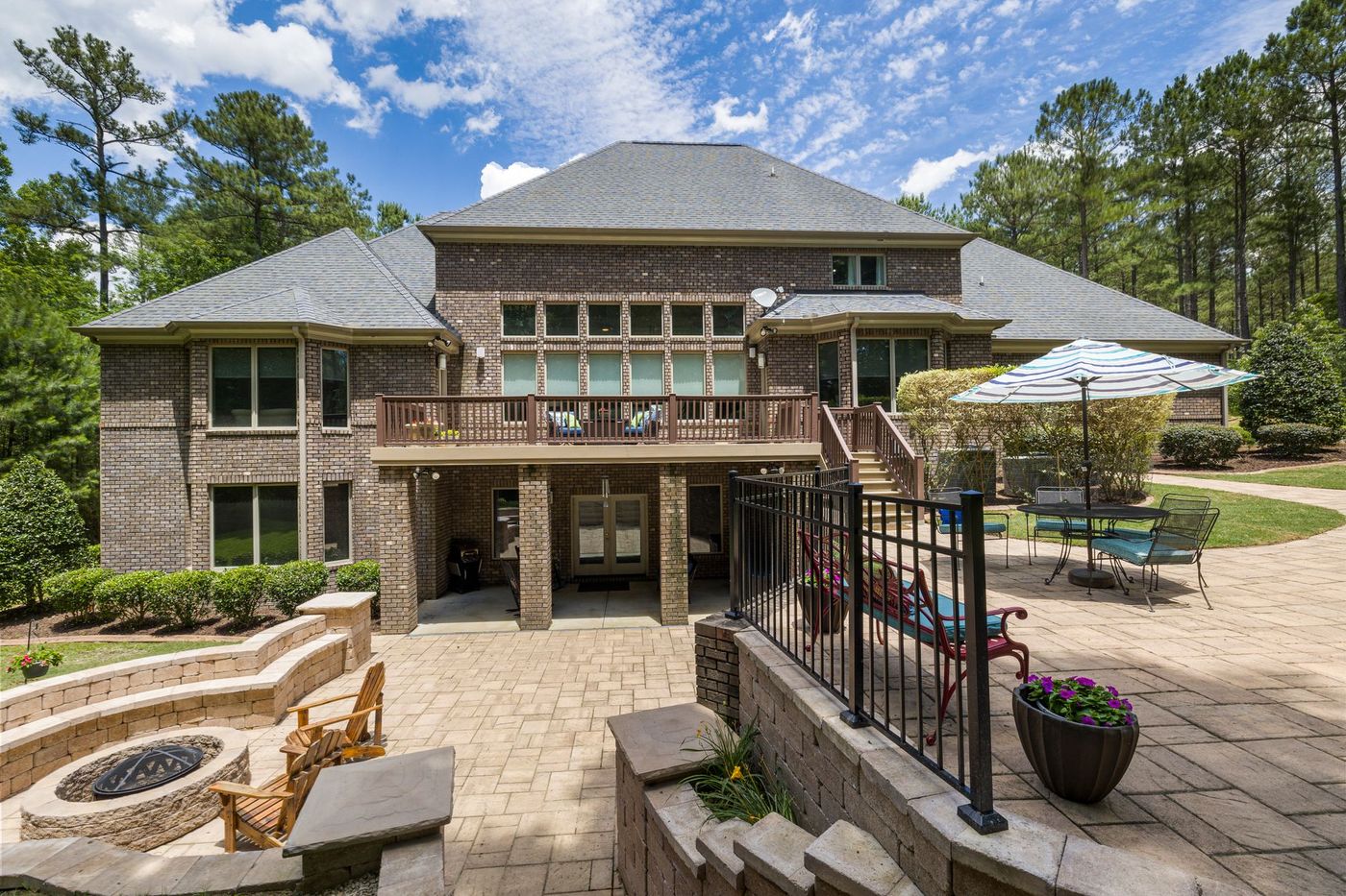 Paver patio with stacked stone fire pit behind a brick home